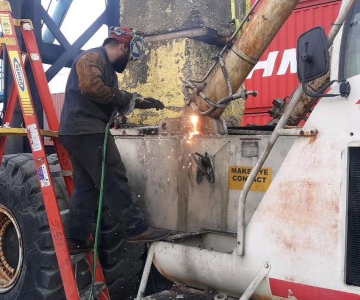 Mobile diesel mechanic repairing heavy equipment on-site