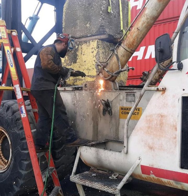 Mobile diesel mechanic repairing heavy equipment on-site